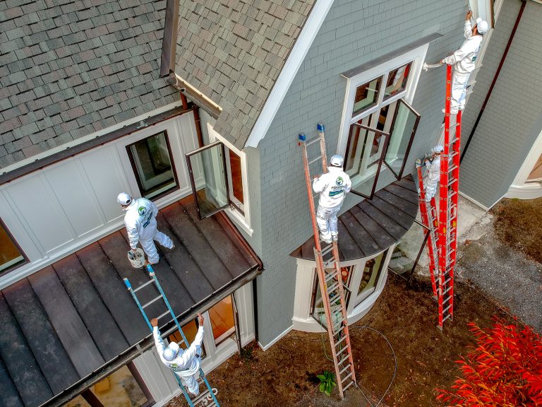 workers on ladder painting large home